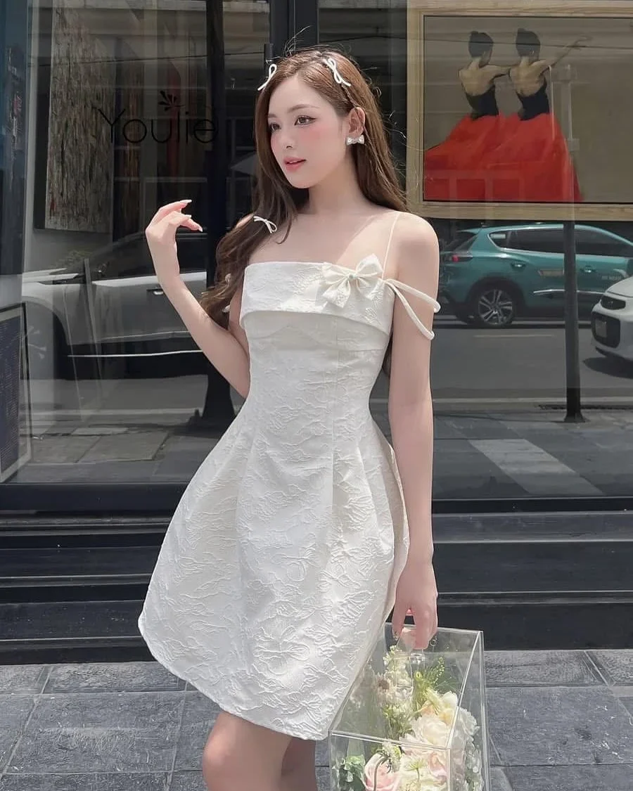 Photo 2 of Váy mini trắng hở vai nơ nữ